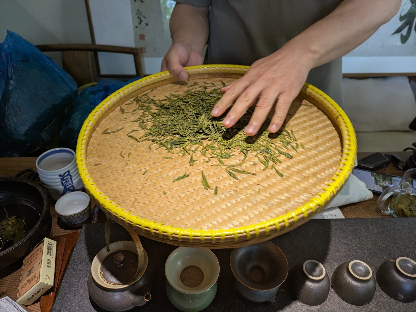 Freshly processed mingqian green tea on a bamboo tray